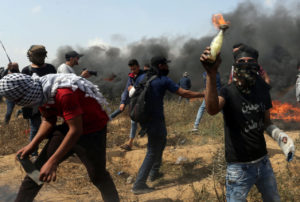 Masked Palestinian holding Molotov cocktail.