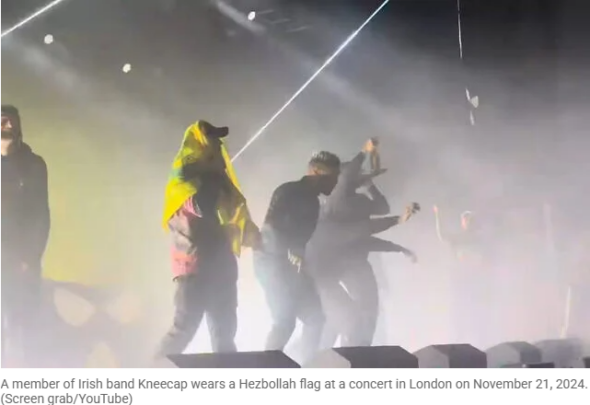 Kneecap frontman Mo Chara wearing a Hezbollah flag